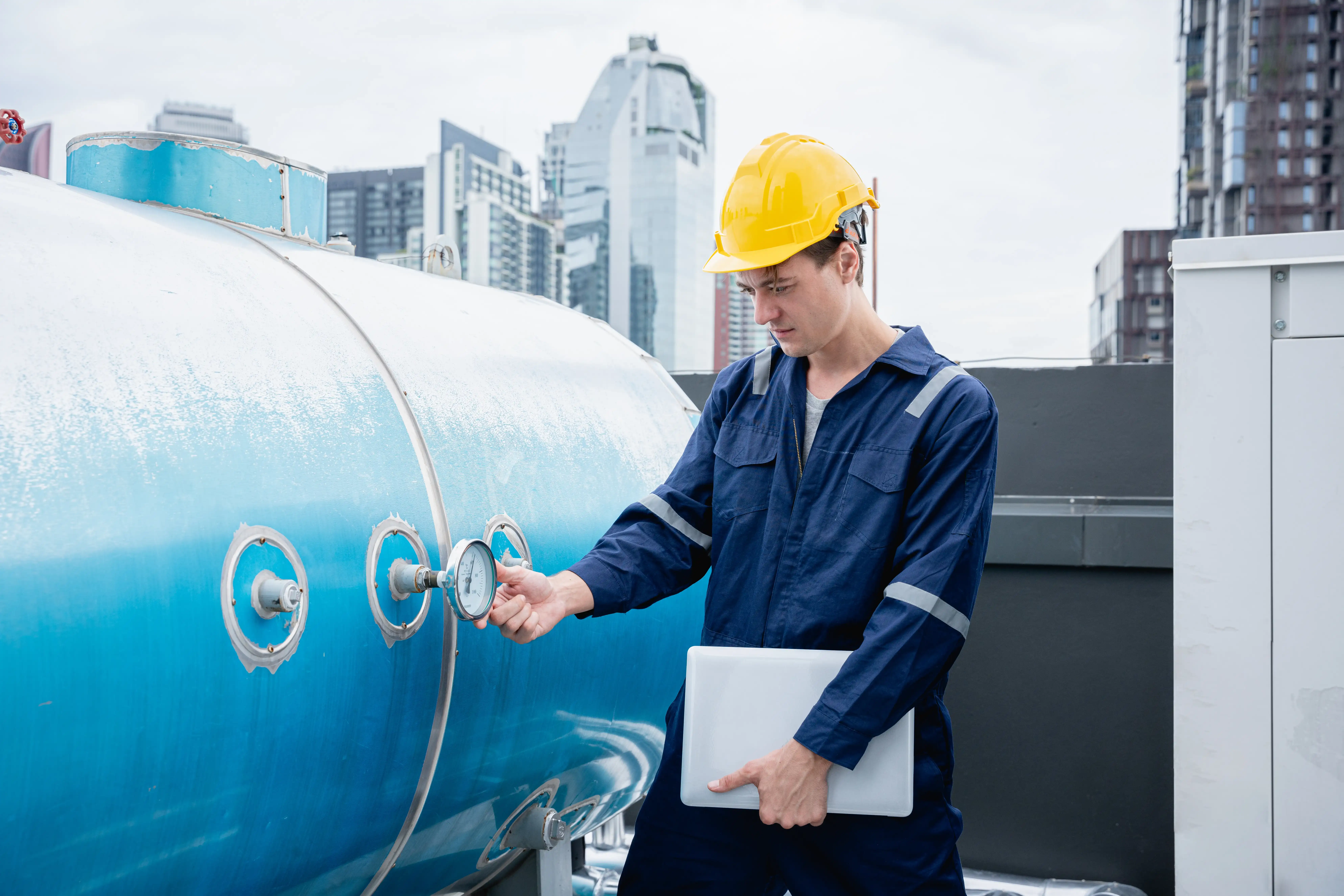 Technician installing a custom pressure tank system with gauges and piping for efficient water flow in a residential property.